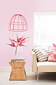 Sofa and wooden side table in interior with pink walls