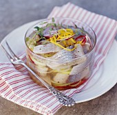 Pickled herring fillets with lemon zest and onions