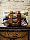 Leather belts buckled around cushions and blankets