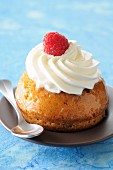 Rum baba with cream and a raspberry