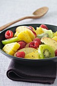 Fruit salad with pineapple, raspberries, apple and kiwi