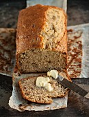 Banana bread, one slice cut, with butter
