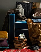 Collection of shiny fabrics and fur on armchair with blue upholstery