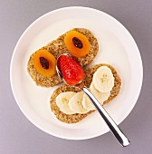 A face made of fruit, with dried apricots, strawberries and bananas on bread