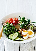 A plate of salad with a boiled egg