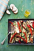 Grilled vegetables on a baking tray, olive oil and slices of white bread