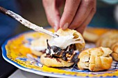 Making smores: filling profiteroles with hazelnut spread and marshmallow