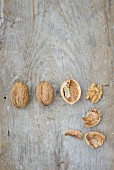 Walnuts, whole and cracked, on a wooden surface