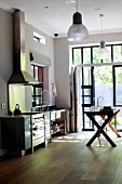 Minimalist kitchen with wooden table in front of open terrace door