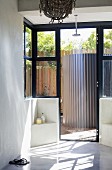 Minimalist shower with open door leading to terrace