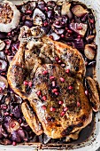Roast chicken with pomegranate, garlic and red onions