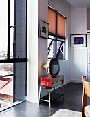 Retrogeräte an weisser Wand in moderner Küche; vom raumhohen Glasfenster der Blick auf das Häusermeer