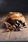 Chestnuts in a paper bag on a wooden table