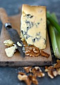 Blue cheese and walnuts with a knife on a chopping board