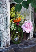 Vase of garden flowers in outdoor fireplace