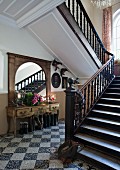 Stairwell of manor house with terrazzo floor and staircase with turned wooden balusters