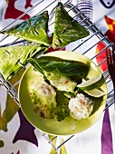 Sea bass wrapped in banana leaf with rice and limes