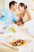 An amorous couple having breakfast in bed
