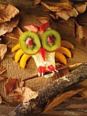A fruit owl surrounded by autumn leaves