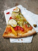 A slice of vegetable pizza with courgette and pepper