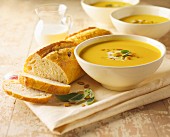 Squash Soup with Sage and Pumpkin Seeds; Sliced Loaf of Bread
