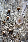 Dried chickpeas on a spoon and on a wooden surface