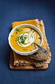 Carrot soup with sour cream, cress and bread