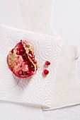 A chunk of pomegranate and pomegranate seeds on kitchen paper