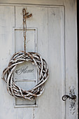 White-painted willow wreath on shabby-chic front door