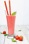 Strawberry smoothie in a glass with straws