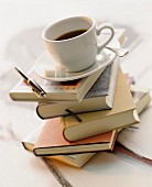 A cup of coffee on top of a stack of books