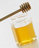 A jar of honey with a honey dipper