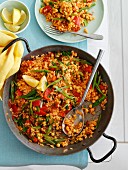 Vegetable paella in a pan and on a plate