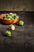 Brussel sprouts in a wooden bowl on a wooden table