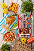 Sommerpicknick mit gefüllten Paprika, Spinatomelett, Müsli, Fisch, Limonade und Wassermelonensalat
