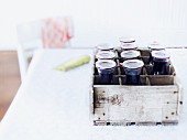Several bottles of home-made elderberry juice in a wooden crate