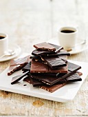 Pieces of chocolate, stacked and coffee cups