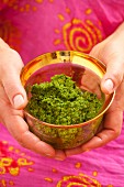 Little girl holding a bowl with pesto