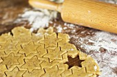 Cut-out almond biscuits, flour and a rolling pin