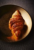 Croissant on a gold plate