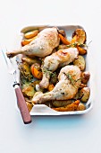 Chicken legs with rosemary on a bed of potatoes and squash