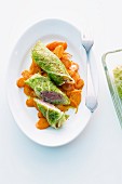 Savoy cabbage roulades on a bed of carrots
