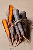 Several purple carrots tied in a bunch