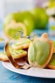 Apple-shaped pastry cutter on plate of biscuits