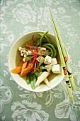 Asian vegetable soup with tofu and enoki mushrooms