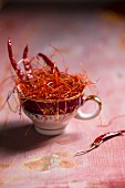 Chilli strands and dried chillies in a teacup