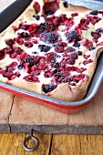 Mixed berry clafloutis cooling on a wooden block