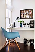 White desk, black accessories, floor-level window and sky blue, 50s retro shell chair