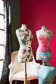 Tailors' dummies covered in floral fabrics against deep pink background