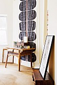 Rustic wooden table in front of wall hanging in bedroom